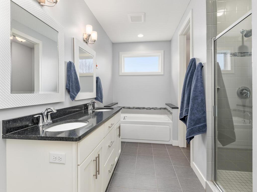 Private primary bath featuring double vanity, soaking tub, and separate shower.