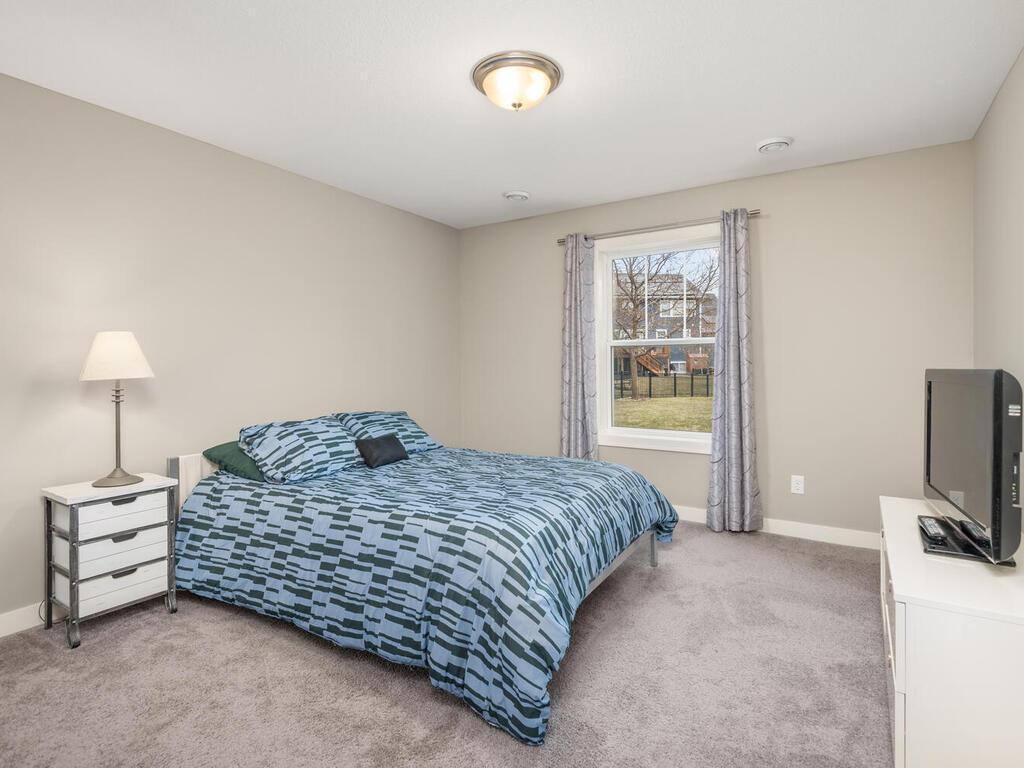 Additional lower level bedroom with a comfortable layout and neutral tones.
