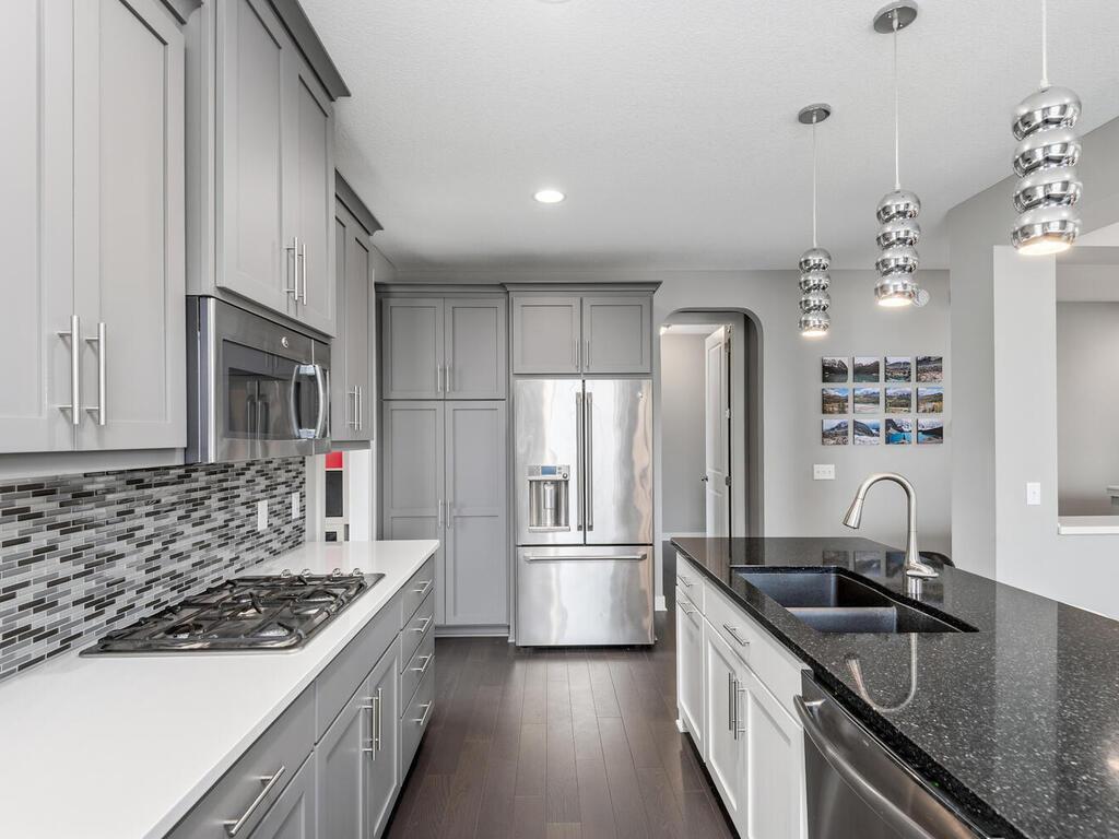 Modern kitchen with stainless steel appliances, walk-in pantry access, and ample prep space.