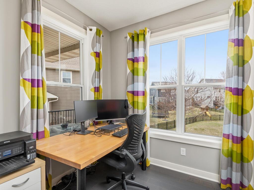 Dedicated main-level office with large windows and backyard views.