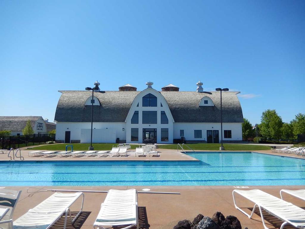 Resort-style community pool with expansive deck and clubhouse backdrop.