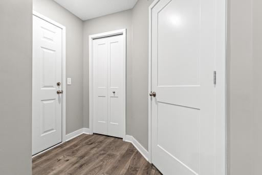 Practical service hallway connecting the 2-car garage to the main home. This functional space features a closet and the utility room, keeping essentials tucked away while providing a perfect "drop zone" for daily entry.
