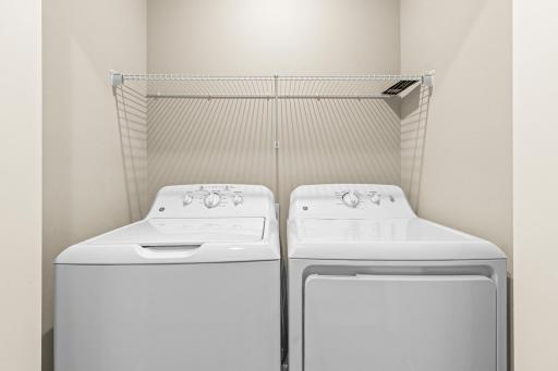 Convenient upper-level laundry tucked behind classic double doors just off the loft. This space features built-in shelving for storage and organization, keeping chores out of sight while providing easy access near the bedrooms.