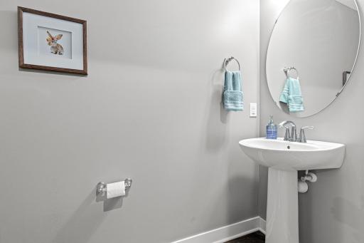 Spacious main-floor powder room conveniently located off the wide hallway. This well-appointed space offers privacy for guests and is perfectly positioned for easy access from the living area and garage entrance.