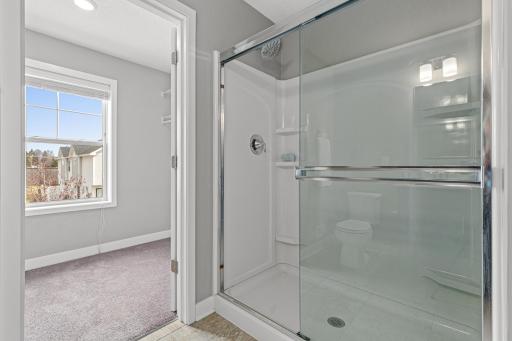 Spacious walk-in shower designed for practicality and ease of use, featuring built-in shelving for convenient storage. The oversized layout provides a comfortable, open feel that perfectly complements the functional primary ensuite.