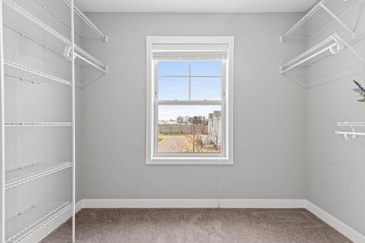 Functional walk-in closet accessed directly through the primary ensuite. This spacious storage area features a window that provides refreshing natural light, making the space feel bright and airy while offering easy organization for your wardrobe.