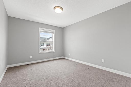 Bright third bedroom featuring a well-placed window for natural light. This view from the doorway highlights the roomâs comfortable proportions and versatile layout.