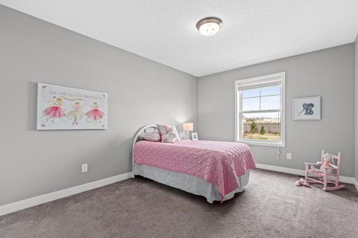 Bright second bedroom featuring a well-placed window that brings in soft natural light. This view from the doorway showcases the room's comfortable proportions and versatile layout.