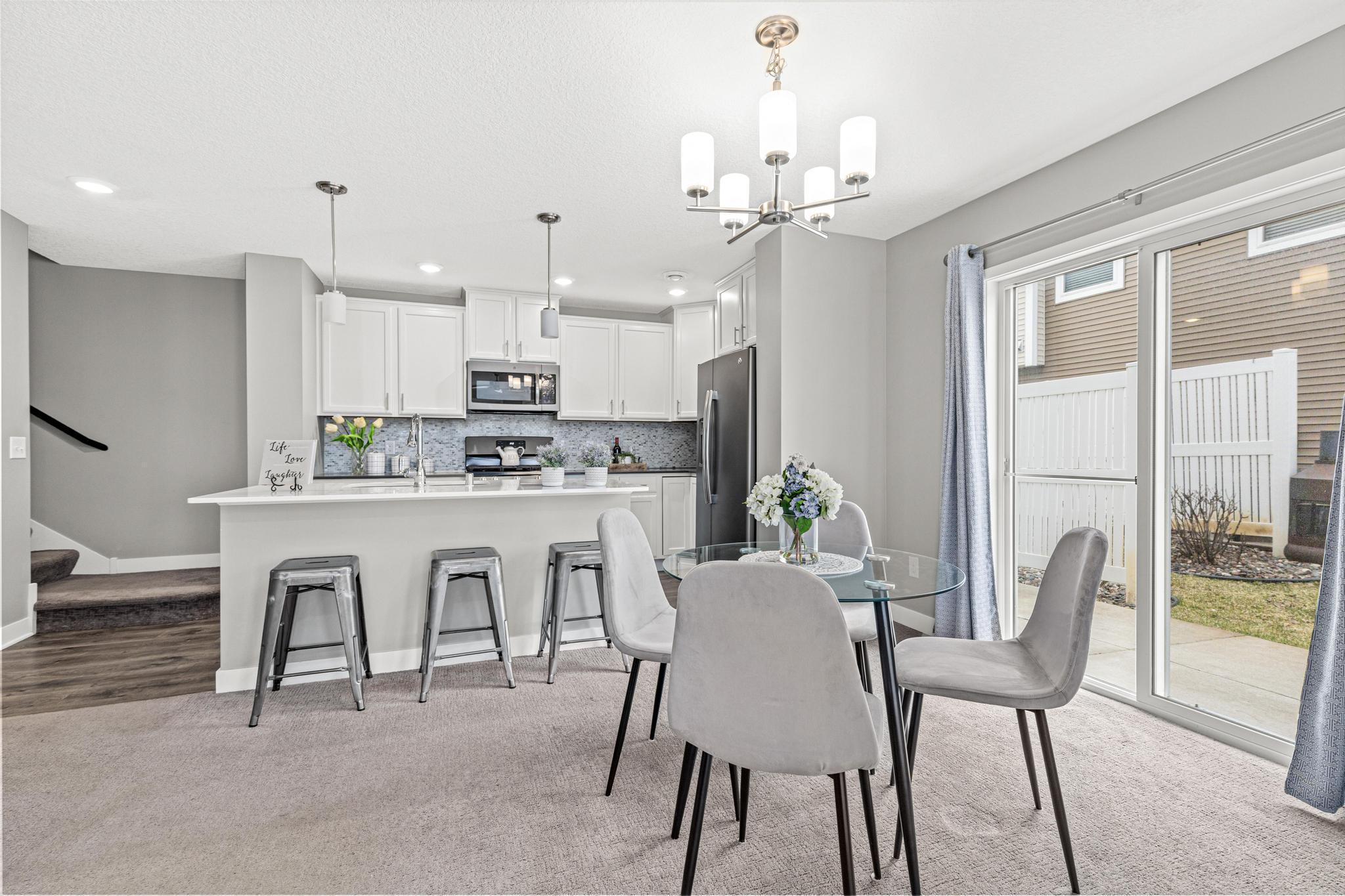 Upper-Level Connectivity: View from the kitchen highlighting the wide staircase leading to the private upper level, which houses all three bedrooms, the versatile loft, and the conveniently located laundry room