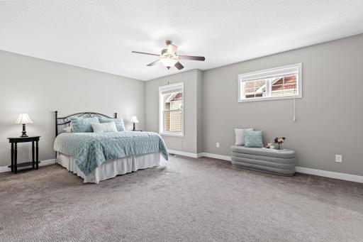Spacious primary suite featuring an ensuite bath and walk-in closet. Two windows provide beautiful natural light, while the ceiling fan adds comfort to this serene retreat.