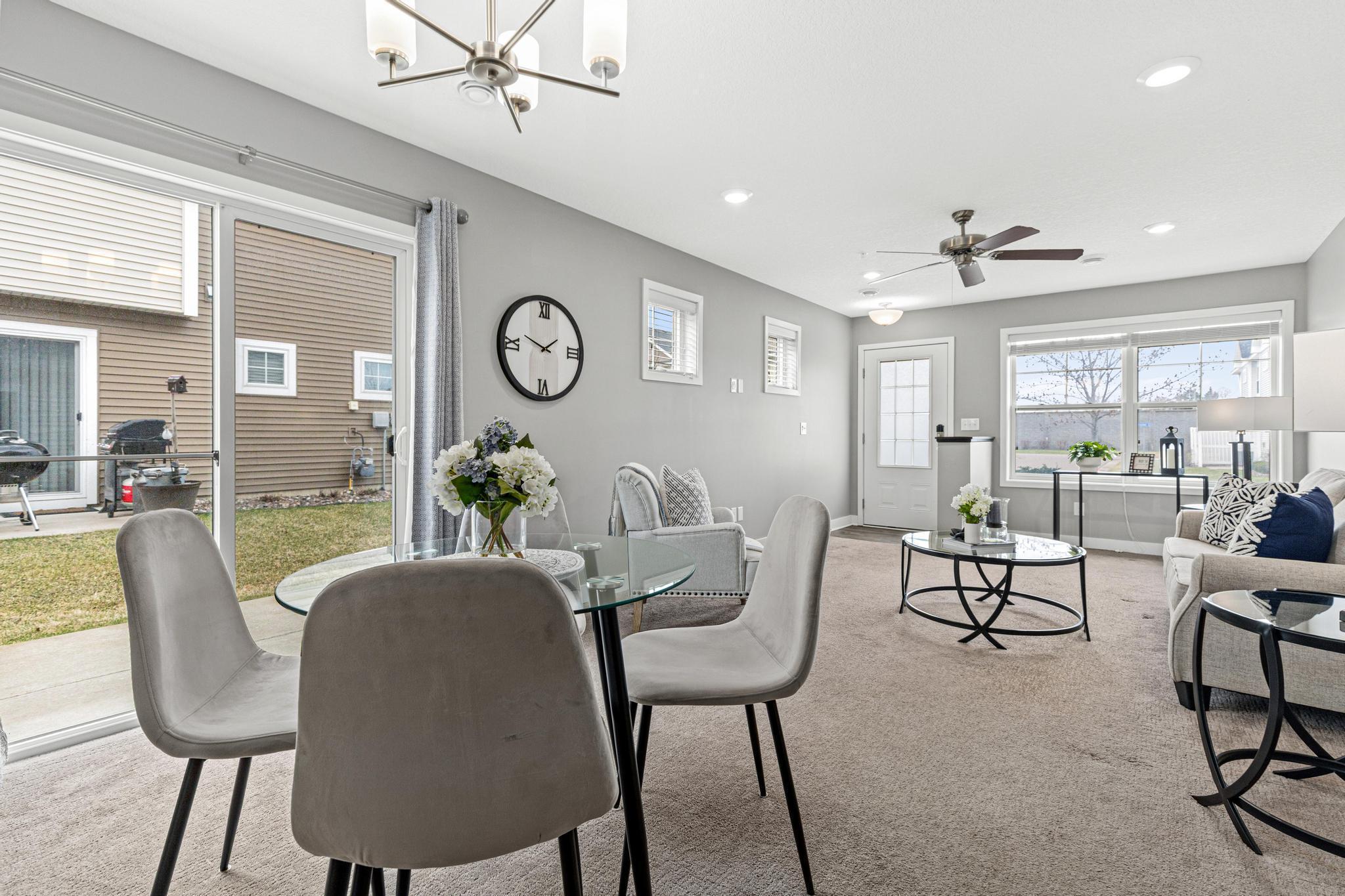 This comprehensive angle from the kitchen captures the entire main level living area. The front door, living room, and patio door all work together to flood the space with natural light, showcasing the seamless flow of this 2018-built home.
