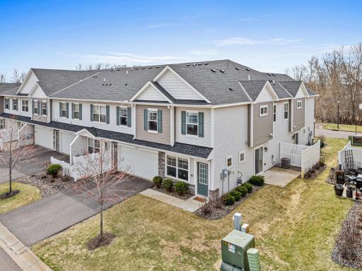 Another view of the side patio and functional green space, perfect for outdoor relaxation. Enjoy a low-maintenance lifestyle as the association maintains the lawn and snow removal, allowing you more time to appreciate the surrounding nature.