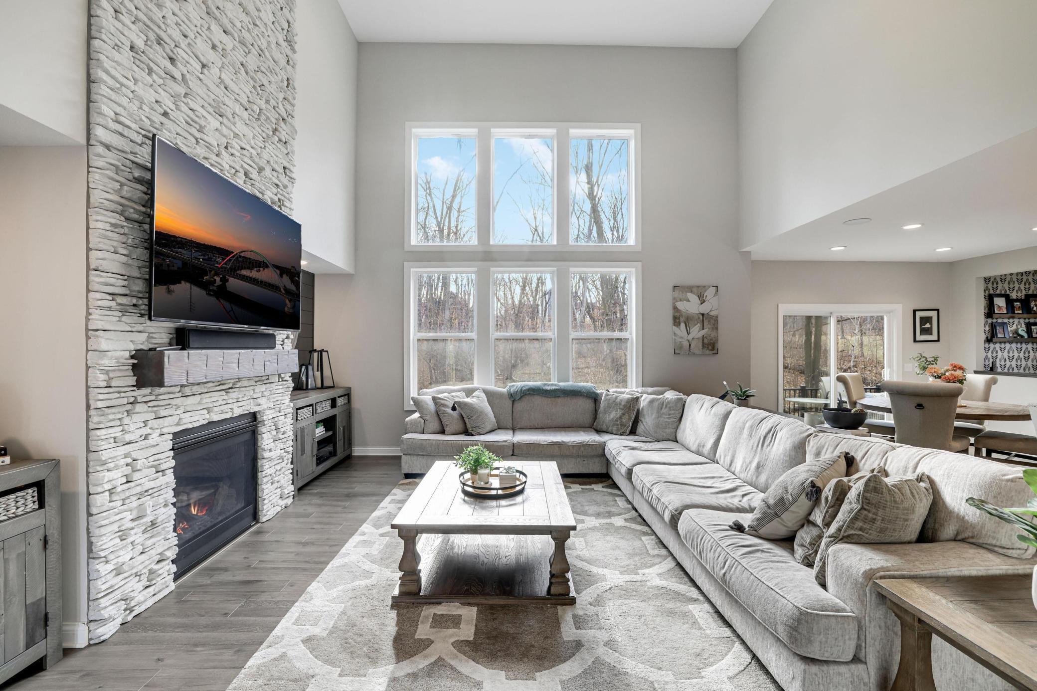 2-story main floor living area at its finest with a full wall of windows, cozy fireplace and room for all