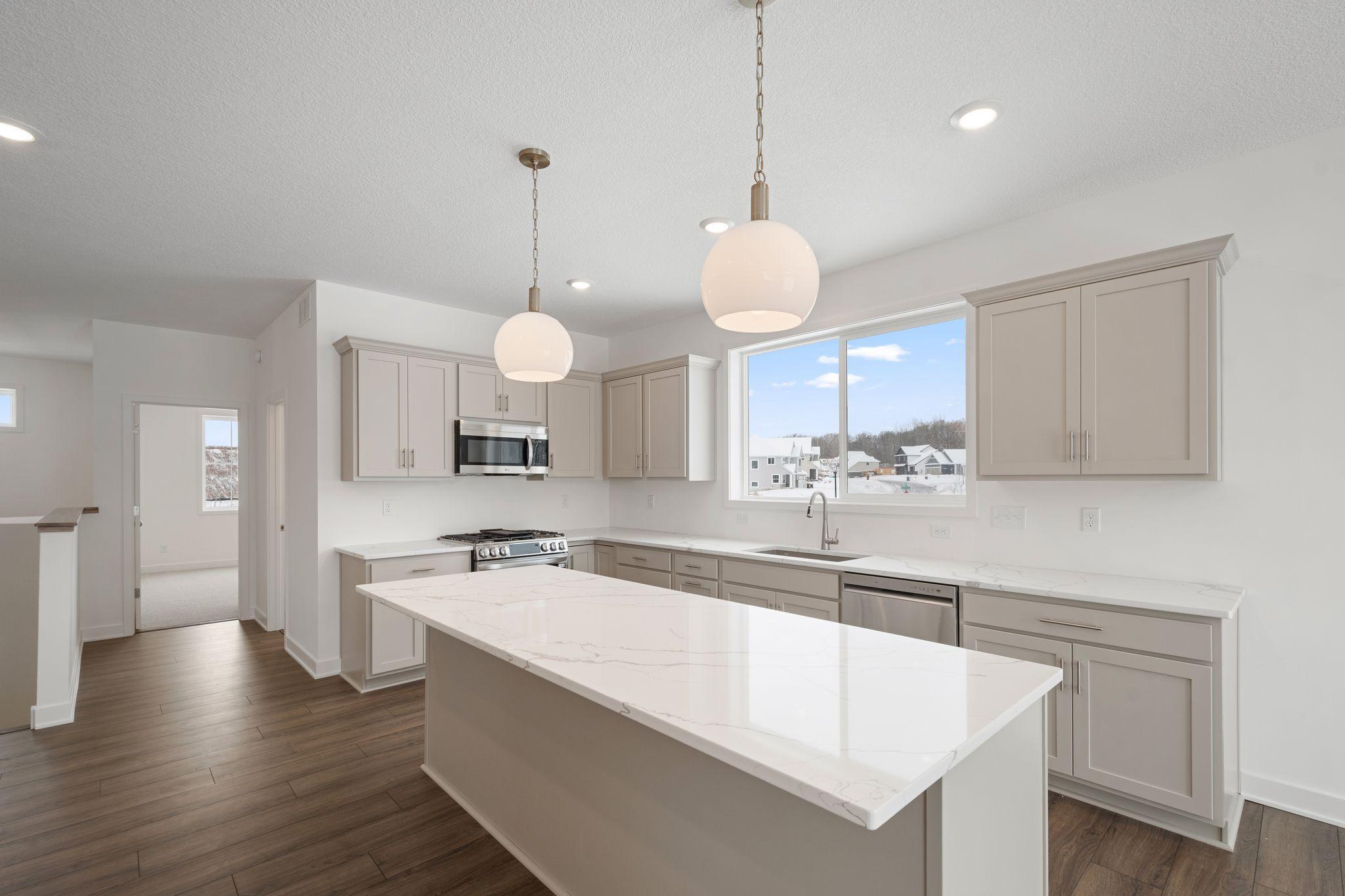 Open kitchen with light gray cabinets and Quartz countertops