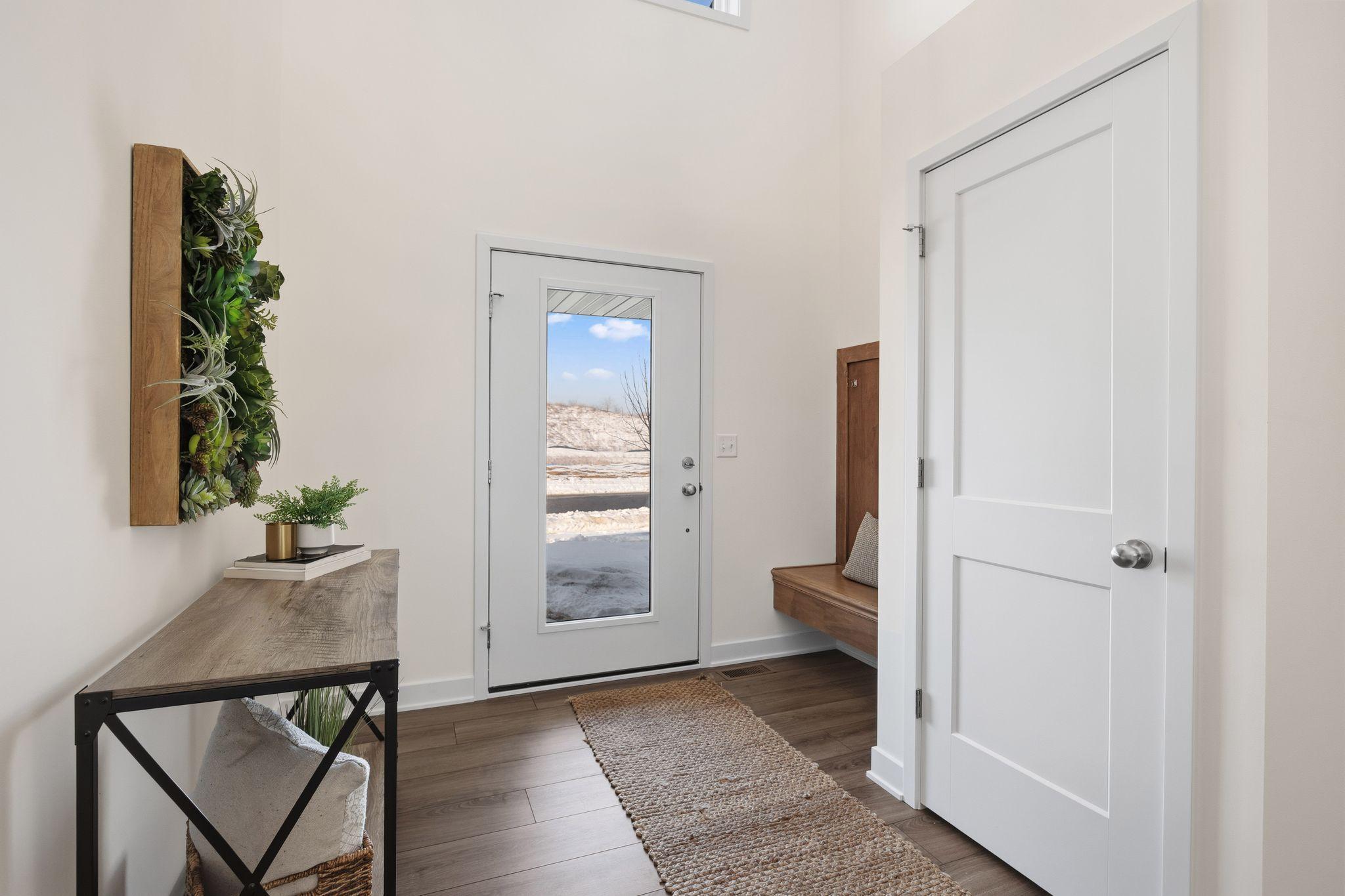 Spacious front entry with custom built-in bench