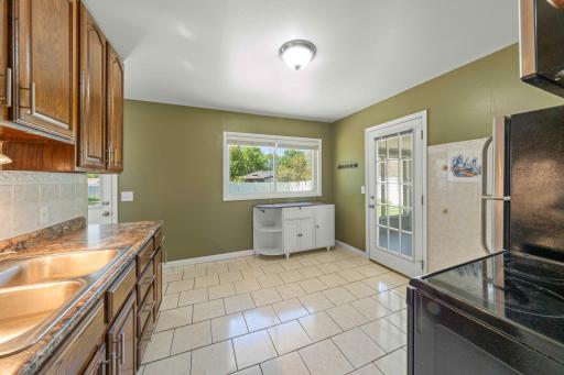 Tile flooring in the kitchen with access door to 3 season porch