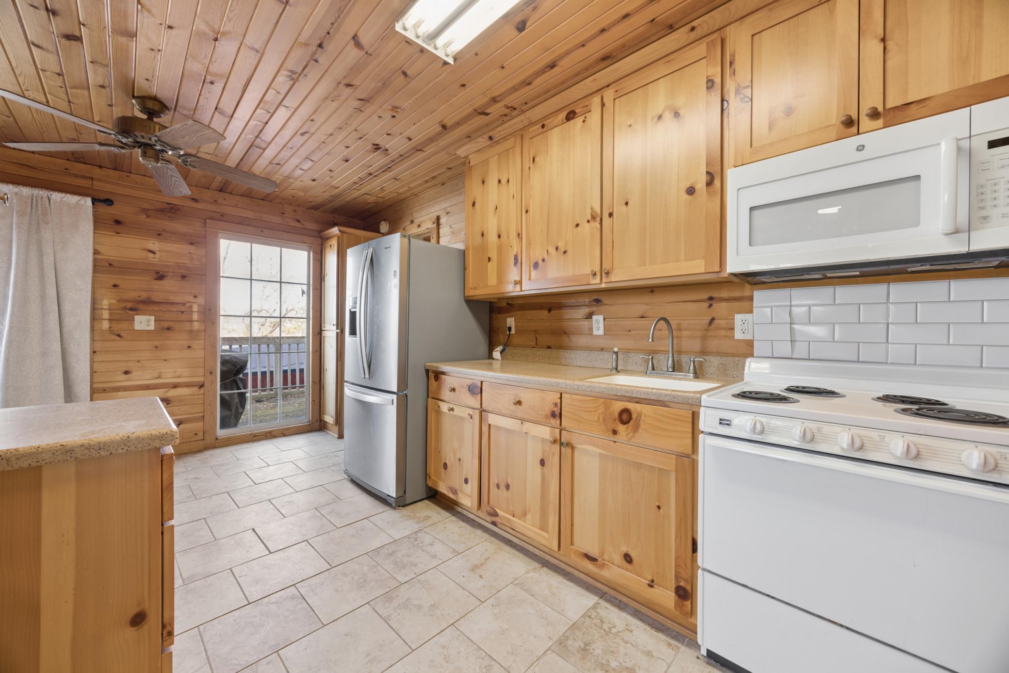 Rustic knotty pine cabinetry in the bunkhouse enhances the cozy lake retreat vibe and makes guests feel right at home.