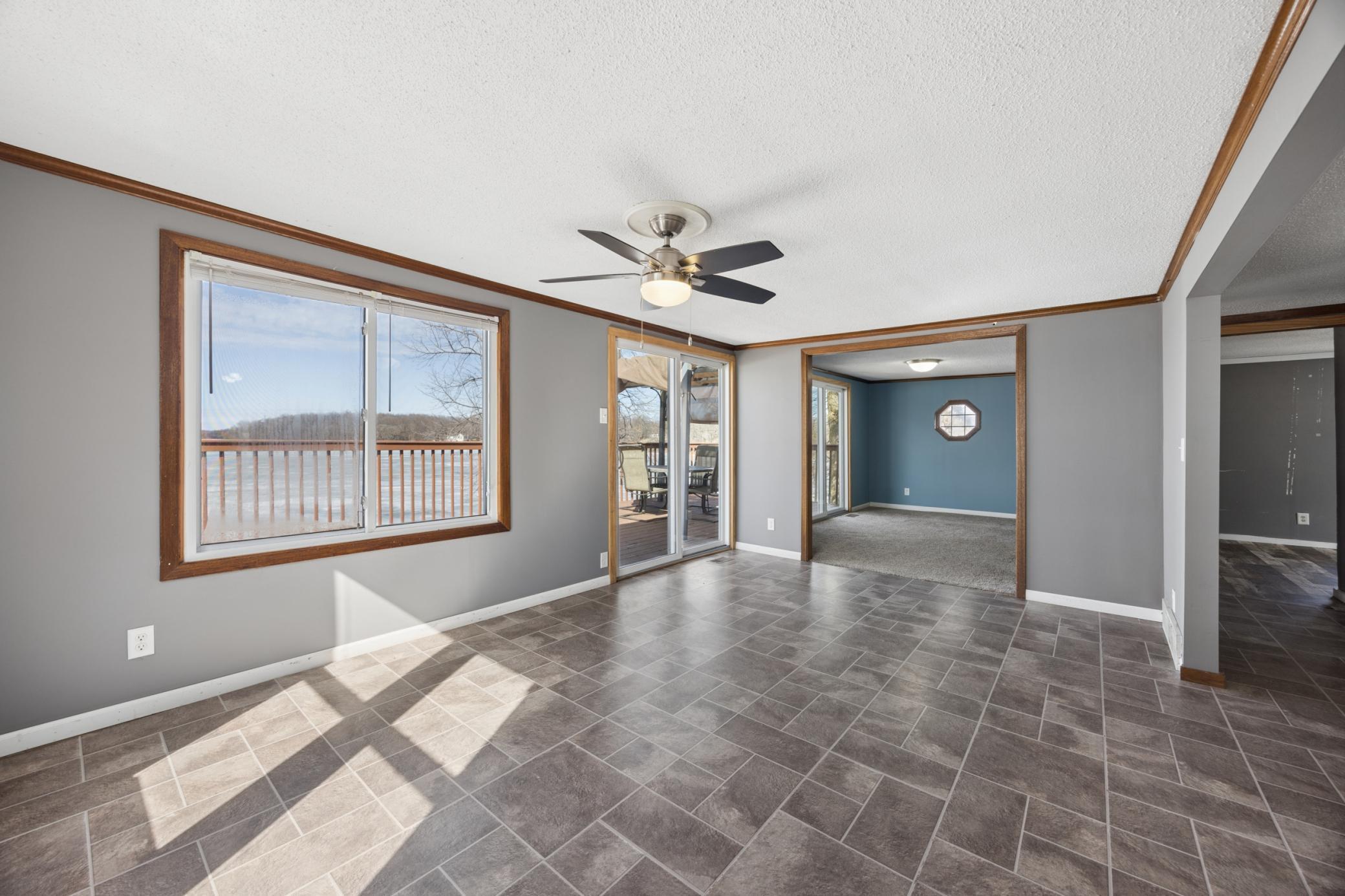 This spacious dining room could double as a second living space. The adjoining living room offers a warm, cozy feel and a patio door that opens to the deck and lake.