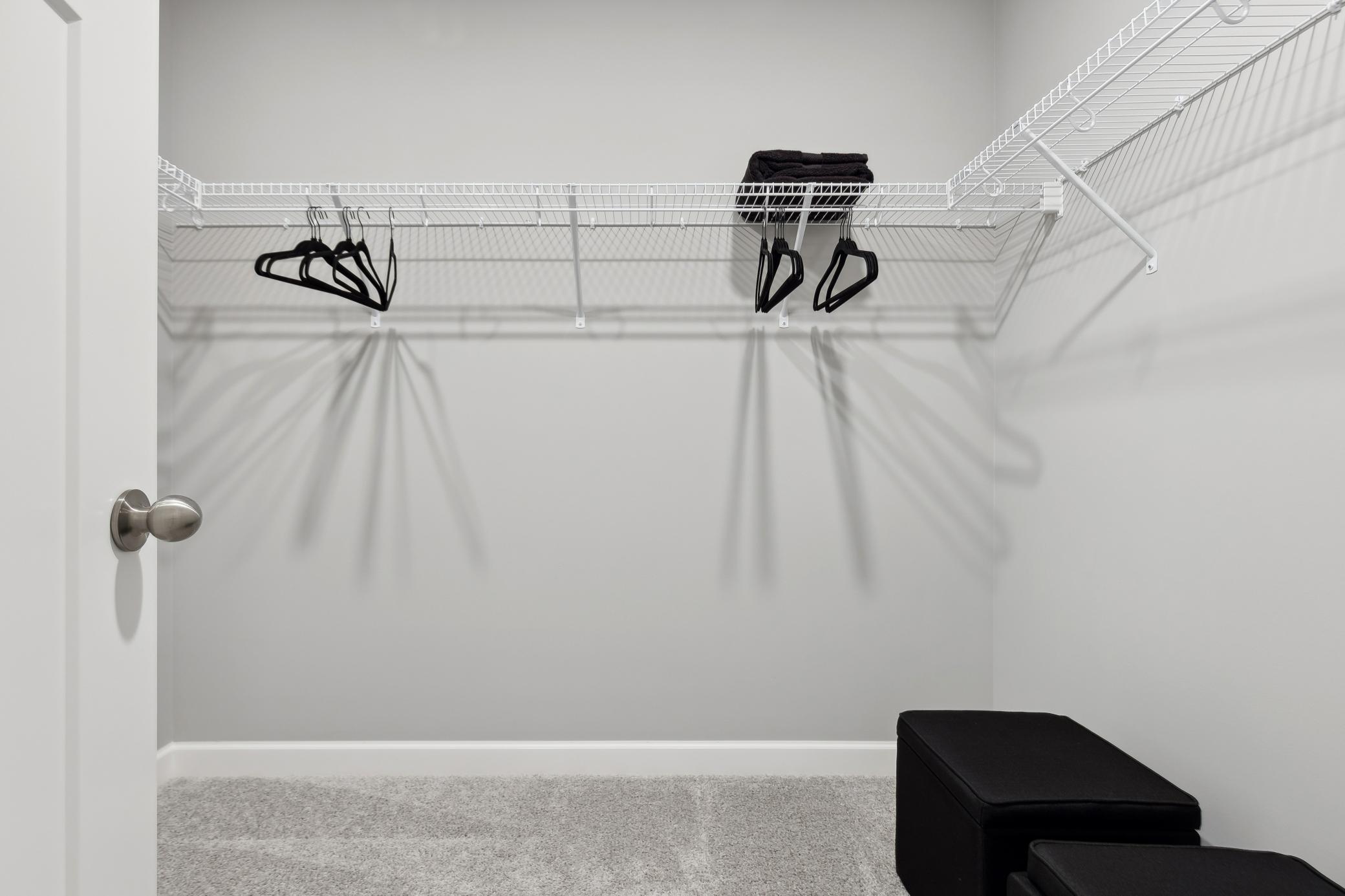 Wire mesh shelving in the walk-in closet provides wardrobe organization
