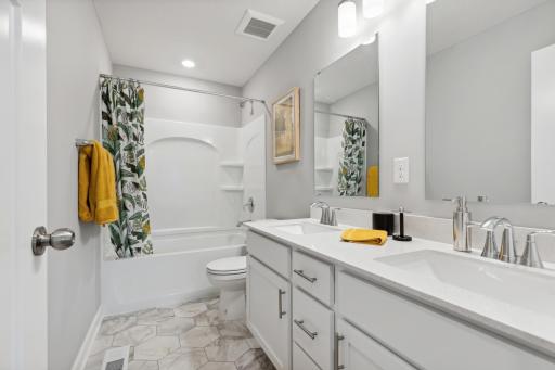 This full-sized bathroom on the second floor conveniently features dual sinks and a shower-tub combination.