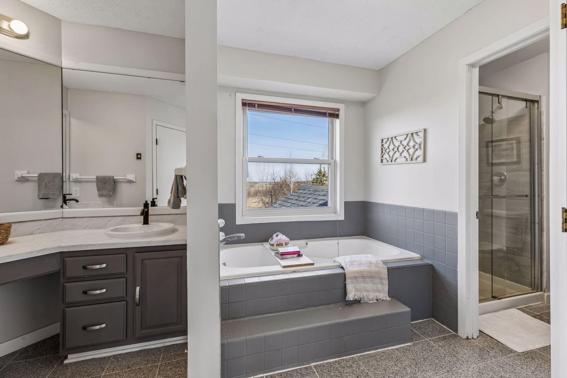 Primary ensuite bath has new sinks, faucets and shower door.