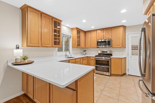 Beautiful kitchen with solid surface countertops, stainless steel appliances and window overlooking backyard.