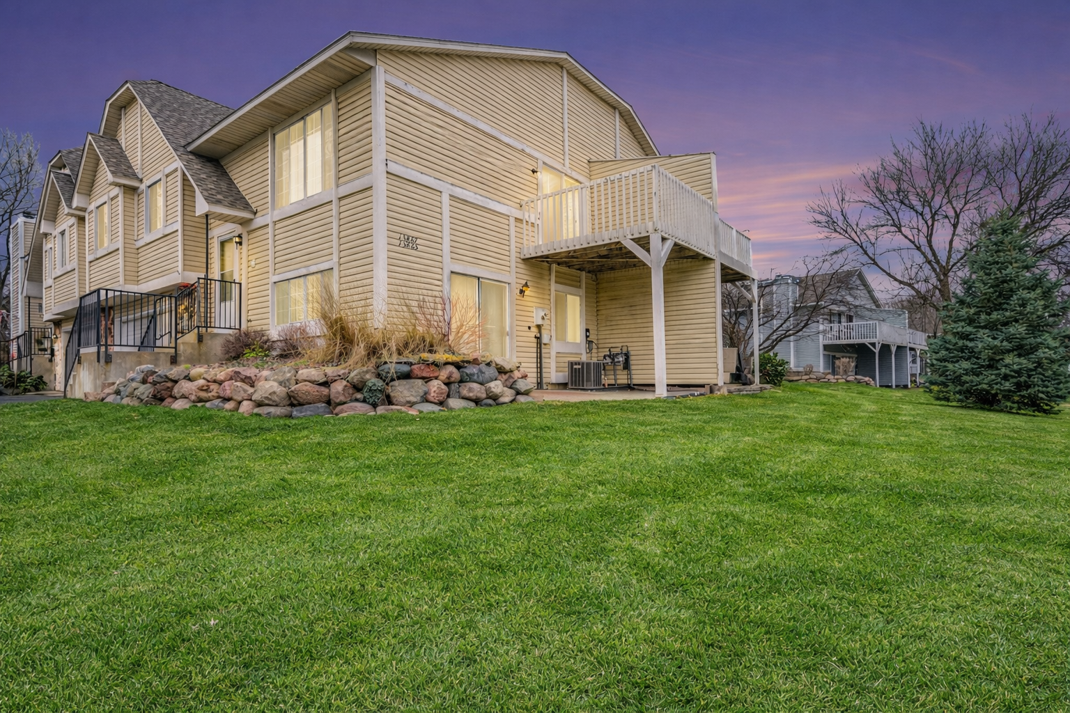 Townhome at dusk with a beautiful landscaped yard.