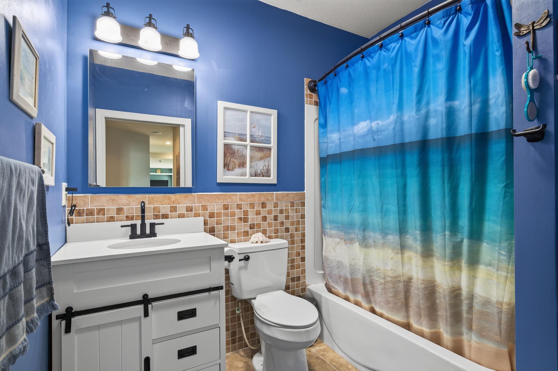Lower level full bathroom with tiled backsplash.