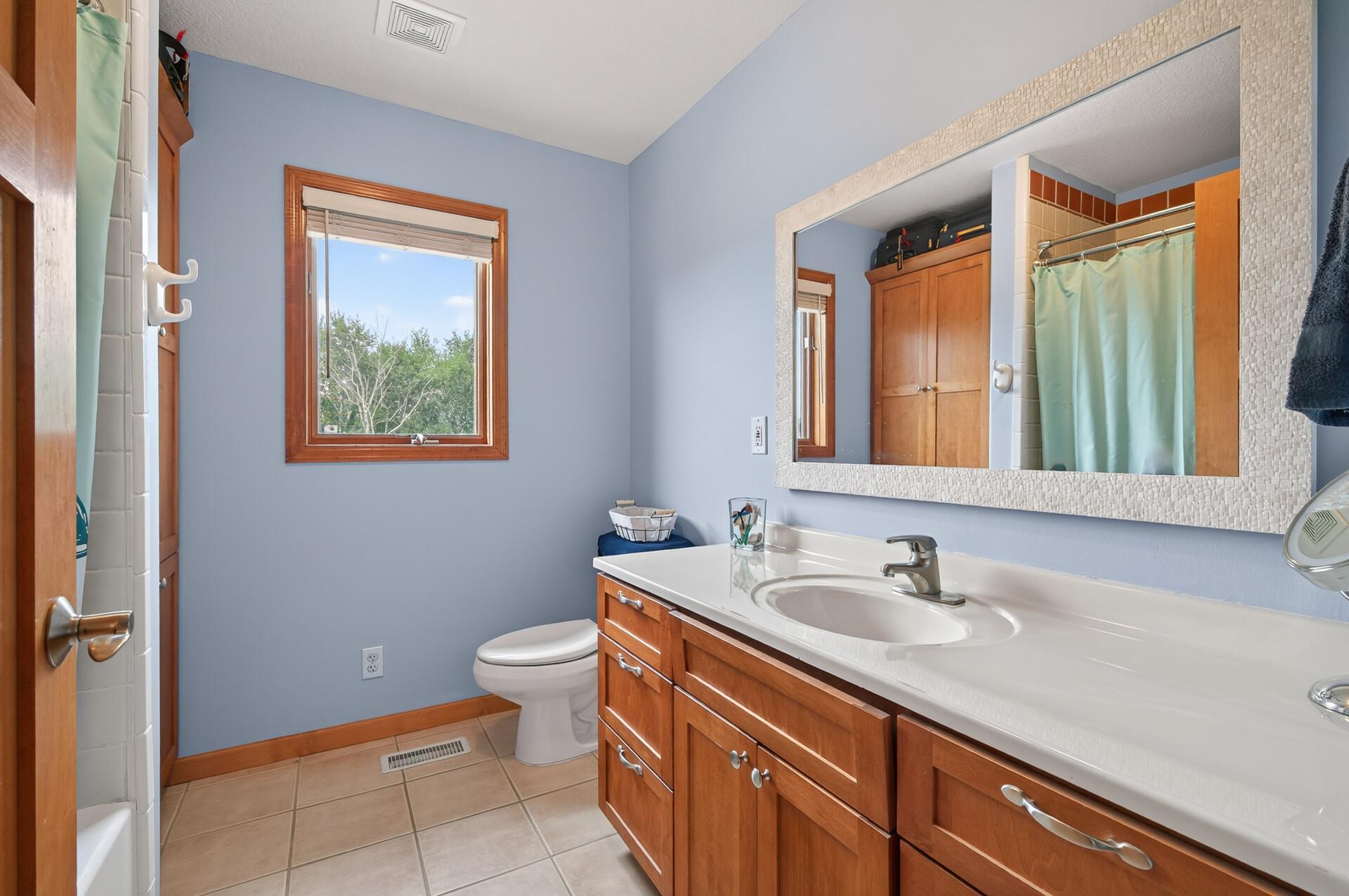 Upper level full bathroom with tiled floors.