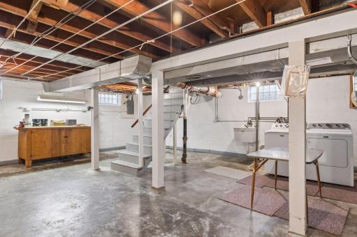 Washer/dryer plus utility sink. Shelving and workshop cabinetry.