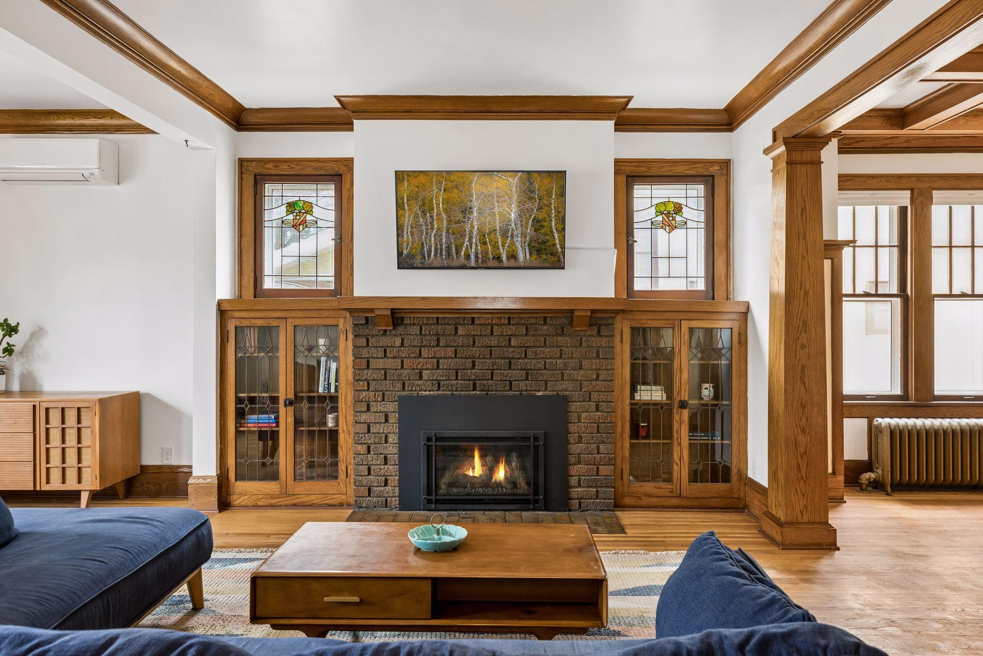 Original leaded glass built-ins, and stunning original stained glass windows surround the brick fireplace.