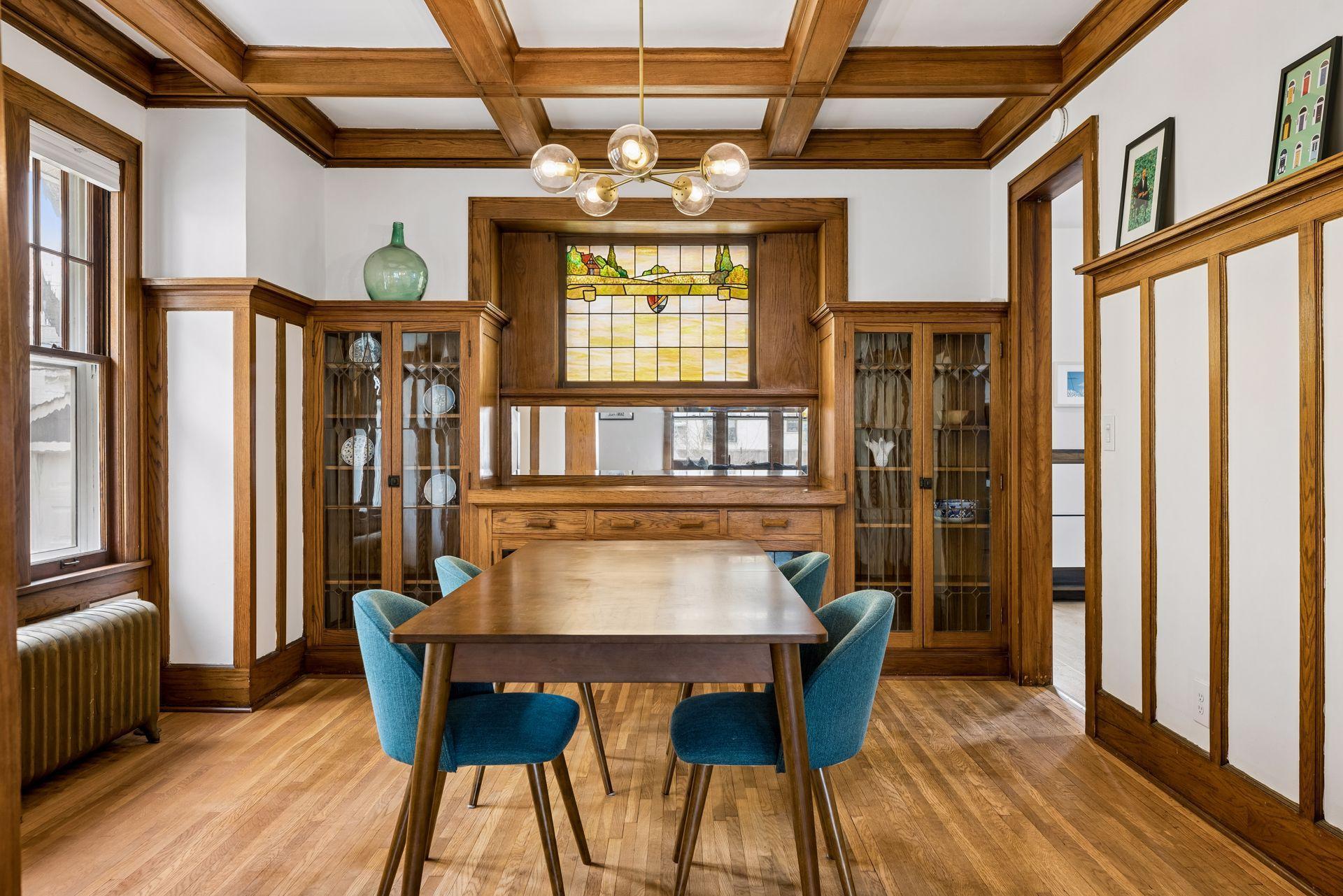 The original details carry throughout the dining room with a full-wall built-in, another stained glass window, picture rail molding, and Coffered ceiling with deep box beams.