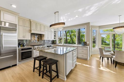 Chef's kitchen features include stainless steel appliances, kitchen island with overhang for seating, and oversized windows