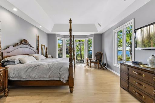 Step into the luxurious primary bedroom suite filled with natural light and access to the deck