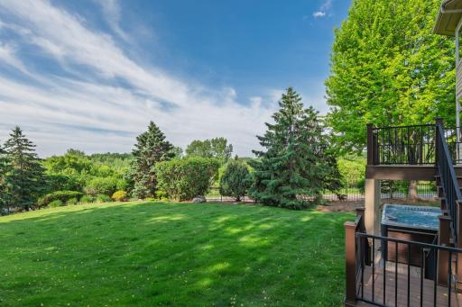 An extraordinary backyard setting unfolds beyond the home, offering expansive green space, mature trees, and a sense of privacy that feels worlds away from the everyday.