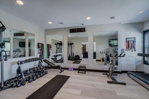 An expansive home gym with mirrored walls and upscale finishes provides exceptional flexibility and could easily be converted into a fourth bedroom with the addition of a closet.