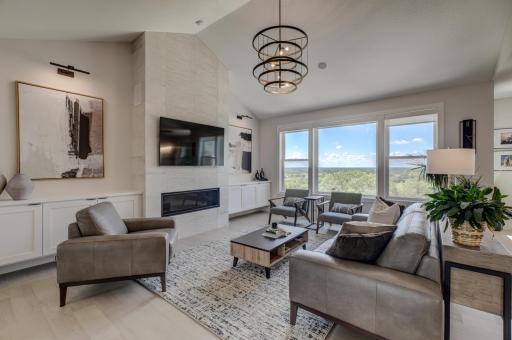 A striking floor-to-ceiling fireplace framed by sleek custom built-ins anchors the impressive living room, creating a warm yet sophisticated gathering space.