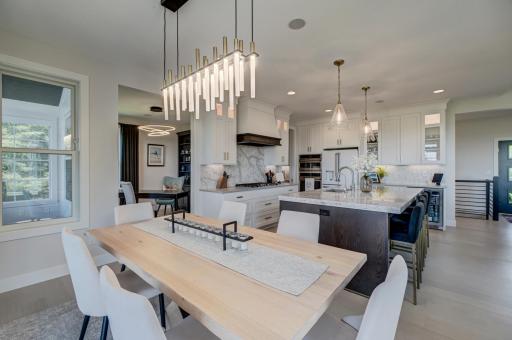 The dining area is highlighted by an eye-catching designer light fixture, offering an elegant setting for both intimate dinners and larger gatherings.