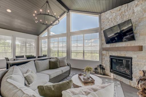 Outdoor living is equally exceptional with a remarkable four-season porch featuring a vaulted ceiling, stone fireplace, and sweeping river valley views.