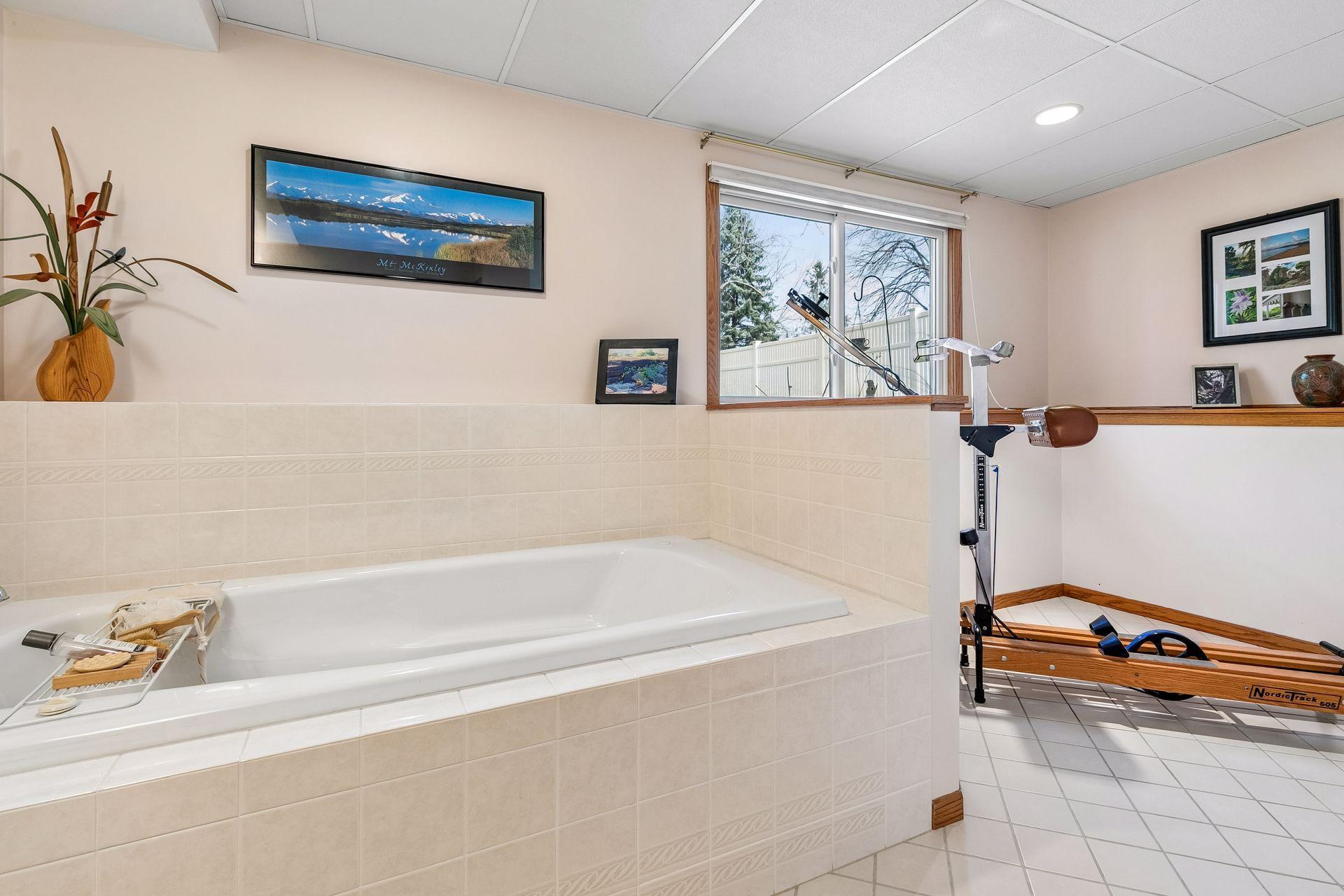 Bonus space in the lower level bath that could accomodate seating, a bench or exercise equipment as displayed.
