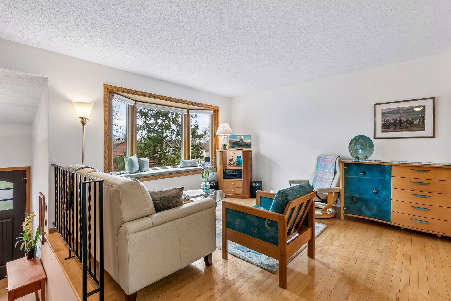The living room offers sunny southern exposure + glistening solid maple hardwood floors!