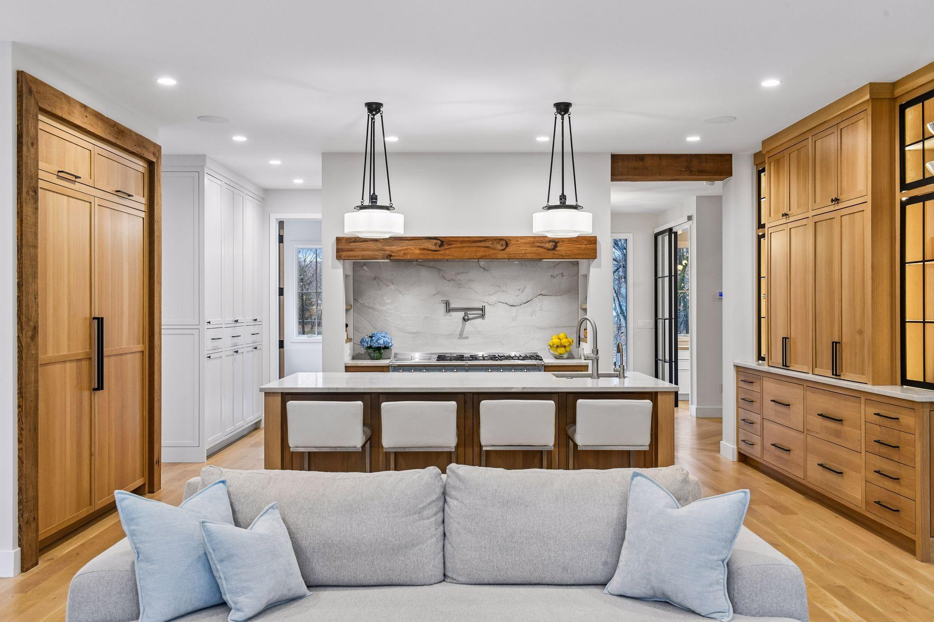A true chef's kitchen with custom 55" Lacanche Sully double oven range with two induction hobs and 5 gas hobs under a hidden and dedicated ventilation system. Range comes with Lacanche griddle, cookies sheets, and wok attachement.