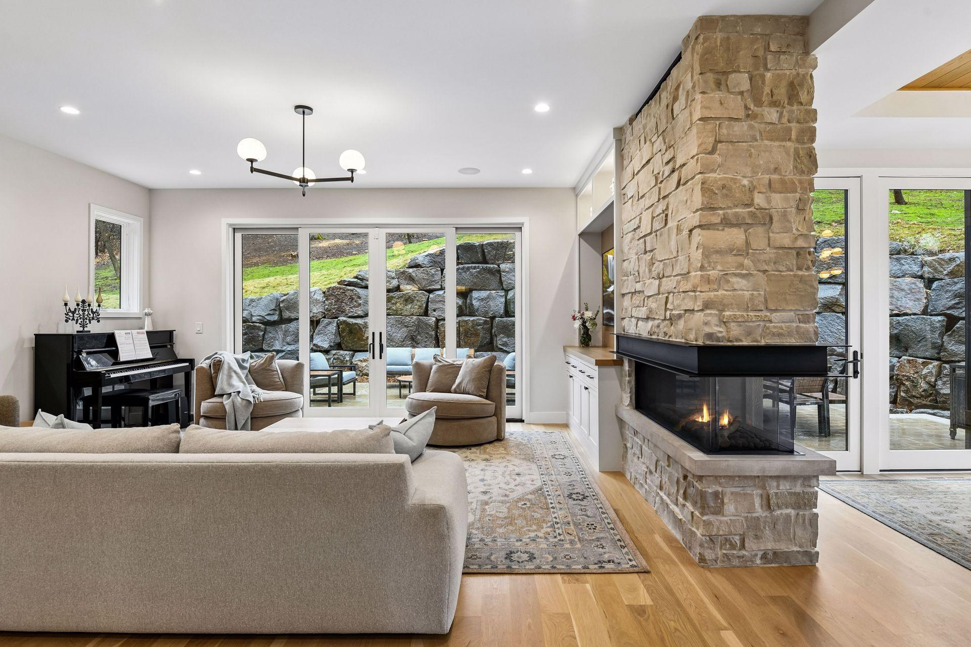 Locally sourced stone above fireplace matches outdoor and ceiling fitted with Sonos sound system.
