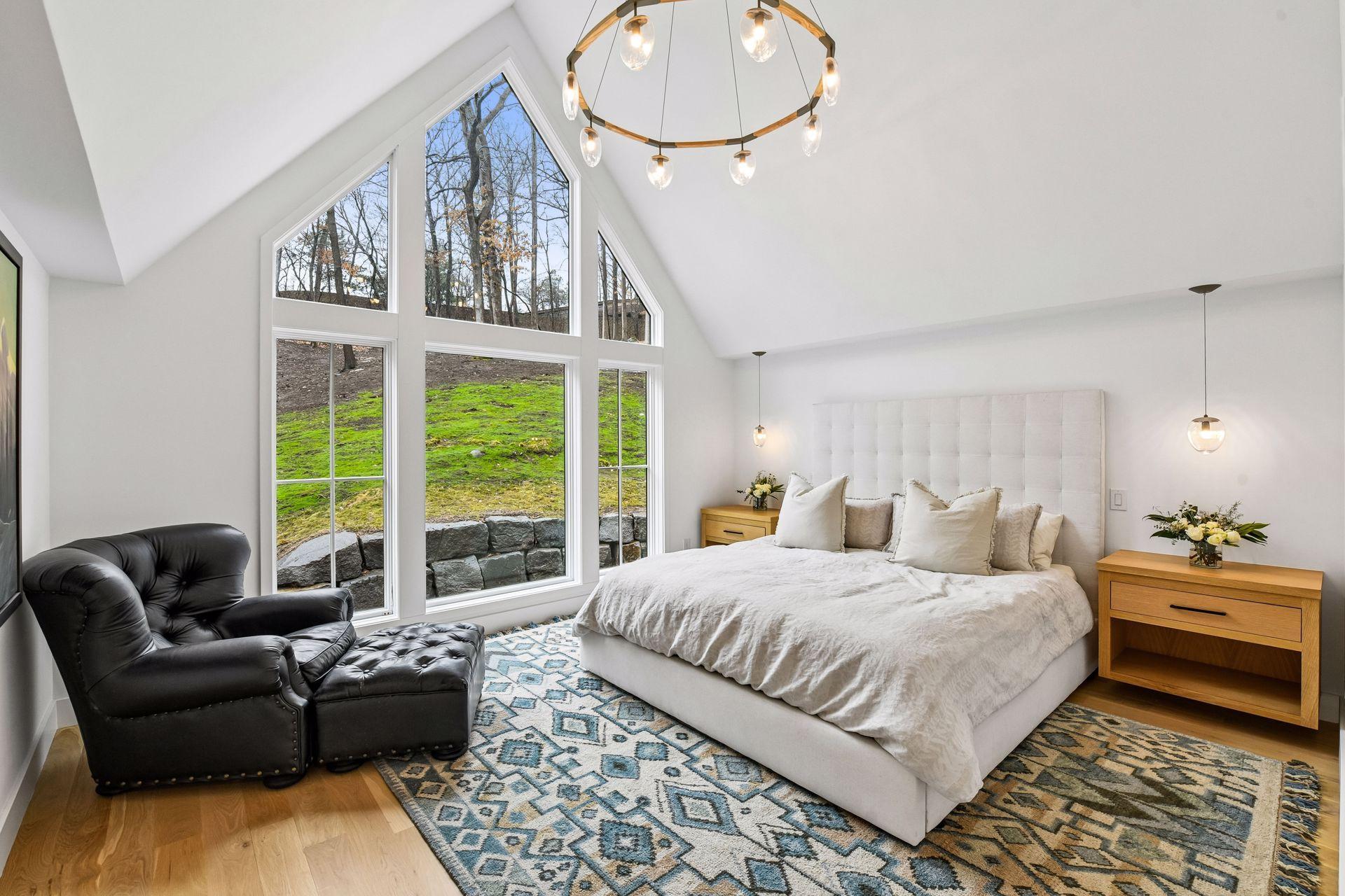 The primary bedroom on the second floor boasts floor to ceiling windows.