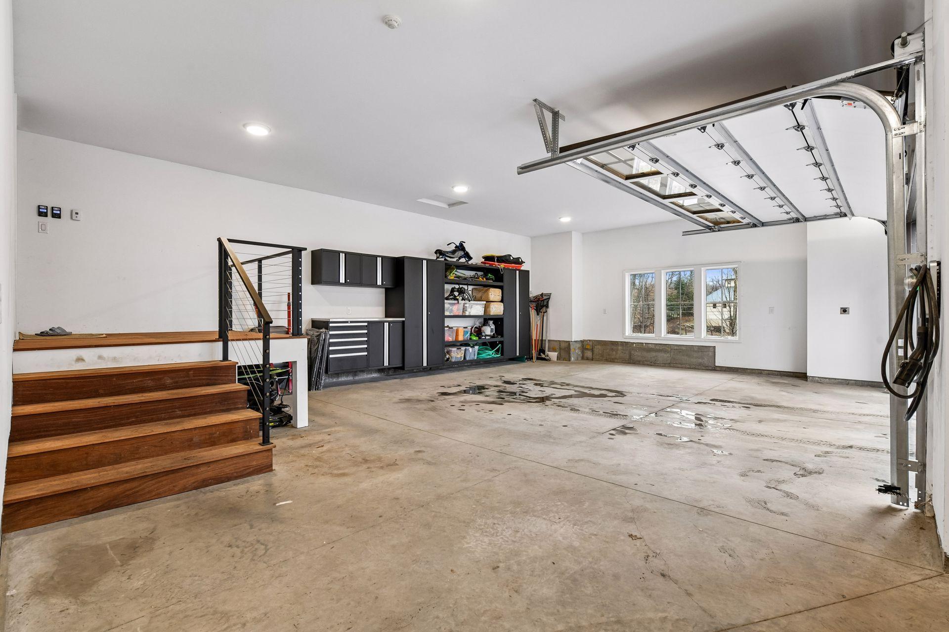 Three car heated garage with two electric car charging stations. Built in metal cabinets for optimal organization.