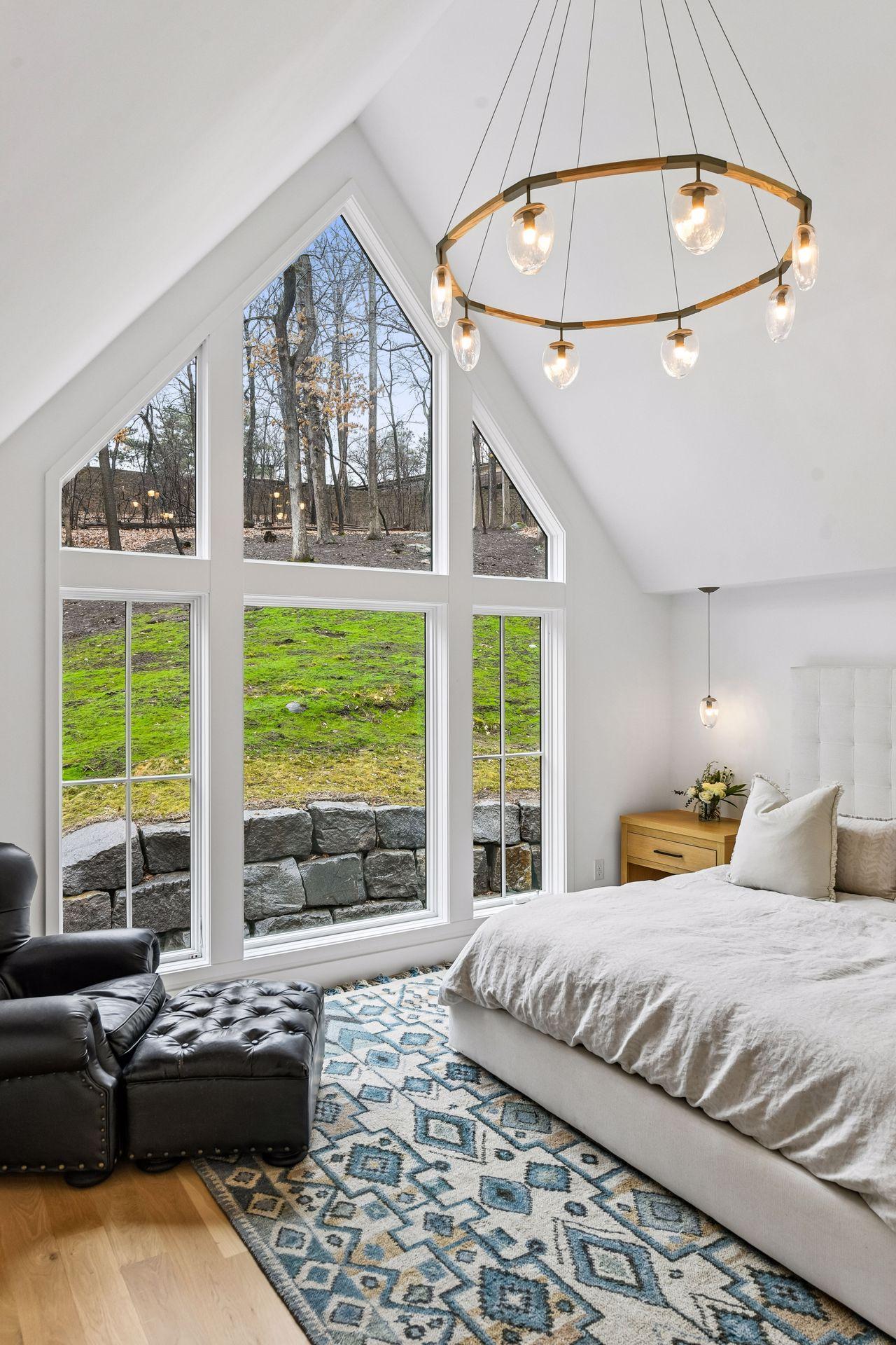 The dimmable custom Hennepin Made blown glass chandilier and coordinating bedside pendants add elegance to this space.