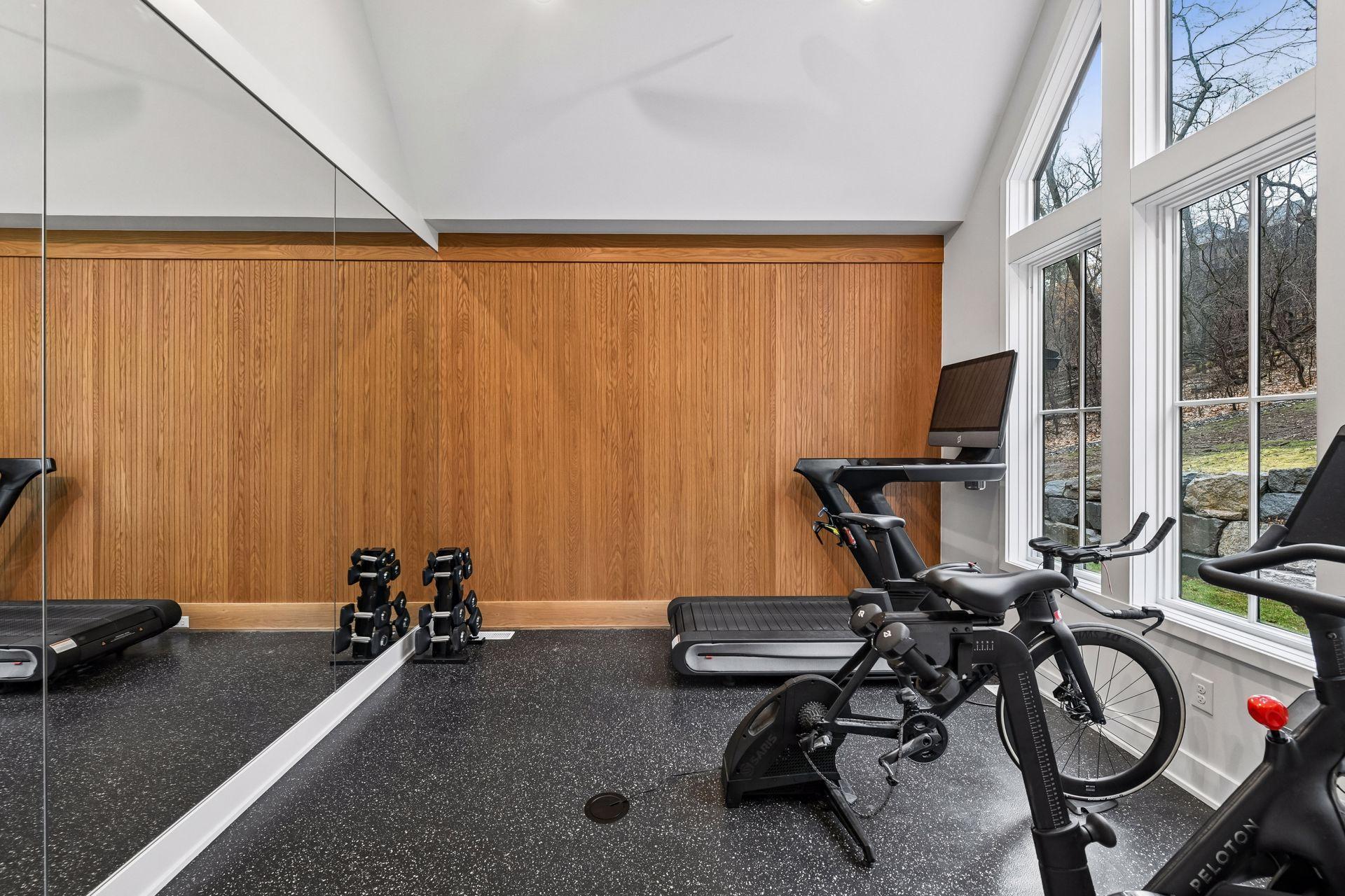 First floor gym for the athlete in your family. Large mirrors are perfect for weight lifting, yoga, dance or pilates while in floor and in wall outlets keep cords organized.