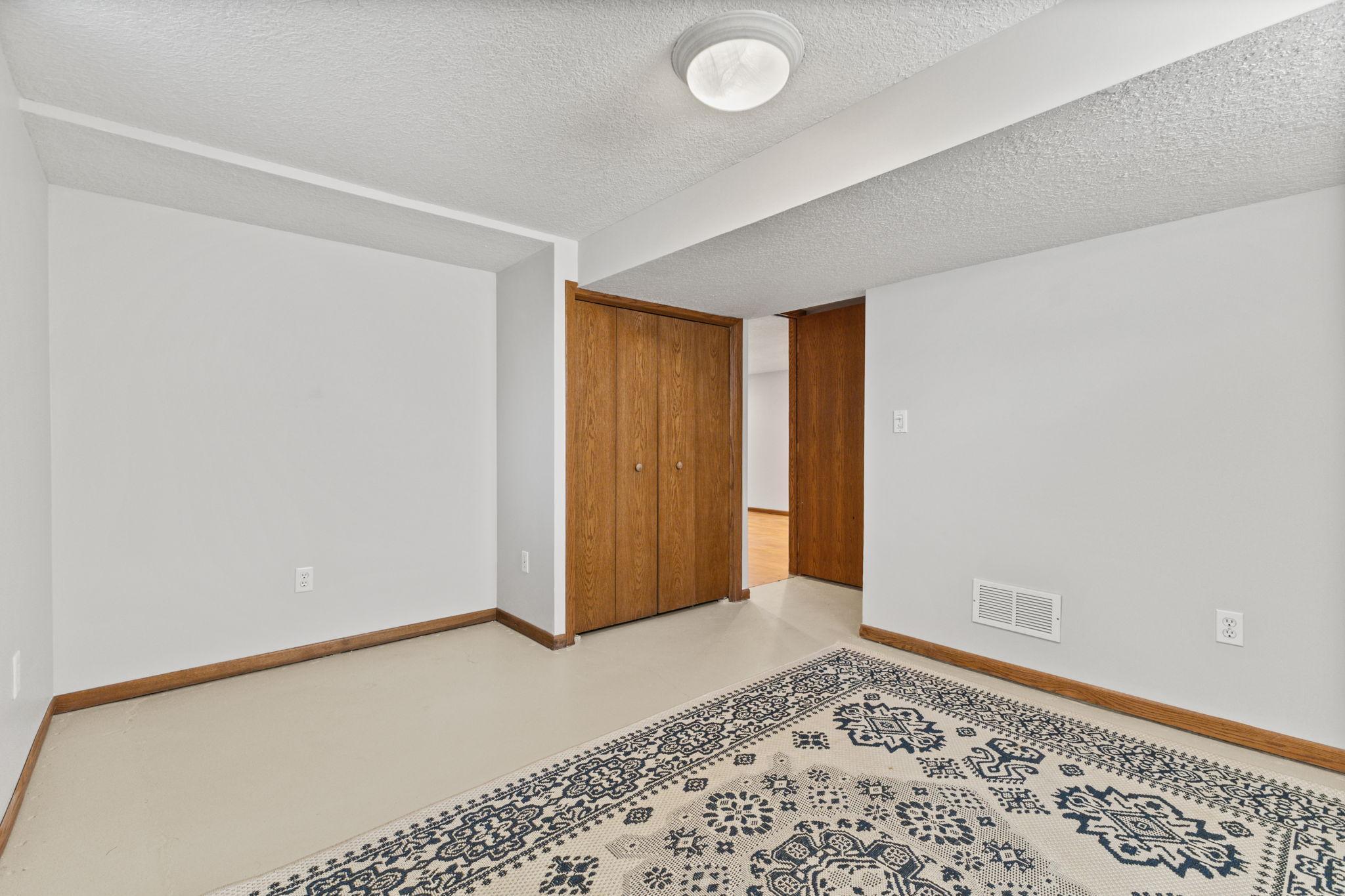 Lower level room with neutral finishes and versatile functionality