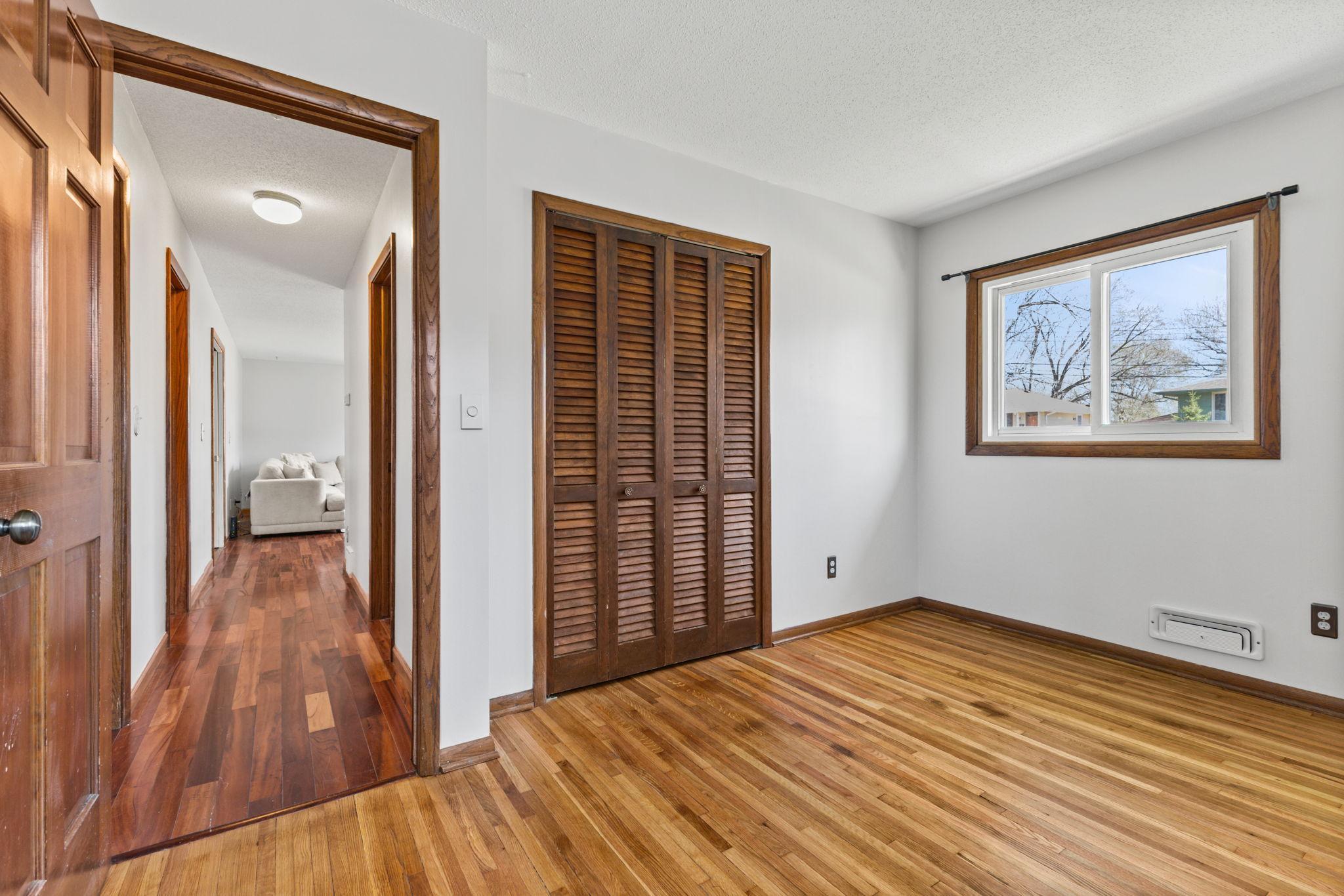 Bedroom with hardwood floors and ample closet space for everyday living