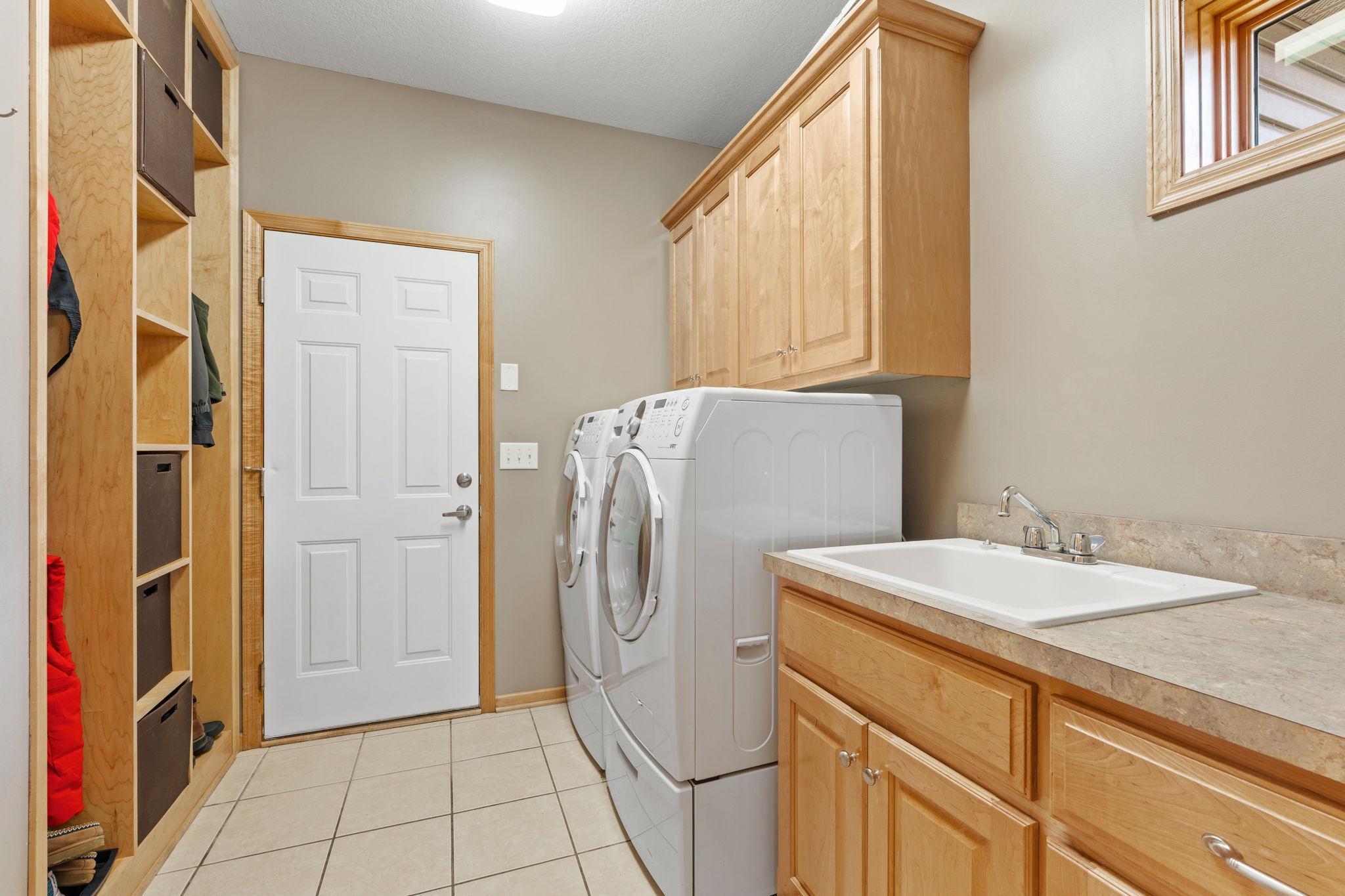 Main Floor Laundry with Built Ins and Sink off the Garage